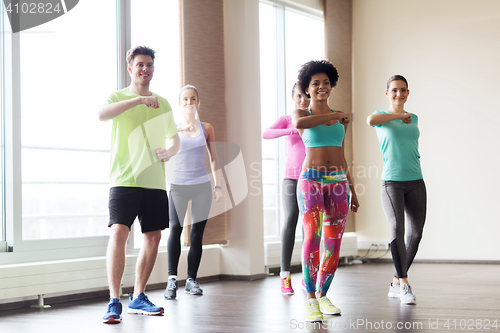 Image of group of smiling people dancing in gym or studio