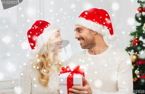 Image of happy couple at home with christmas gift box