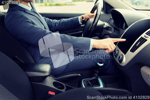 Image of close up of young man in suit driving car