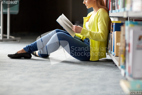 Image of high school student girl reading book at library