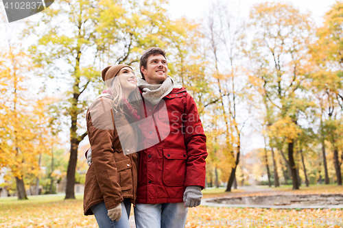 Image of happy young couple walking in autumn park