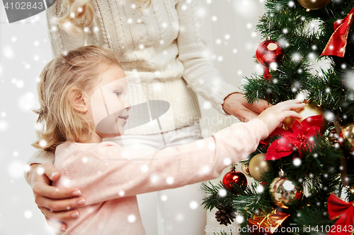 Image of happy family decorating christmas tree at home