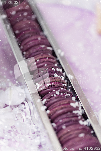 Image of Purple macarons lying in silver box