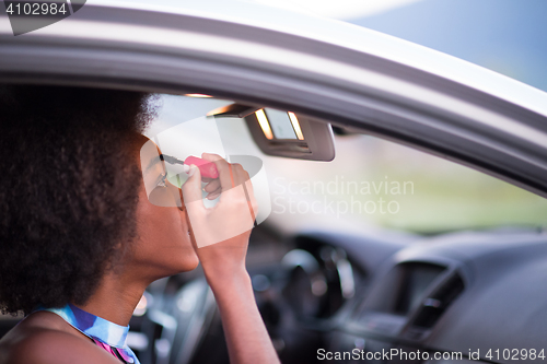 Image of a young African-American woman makeup in the car