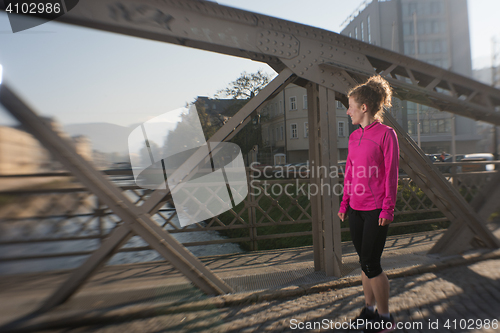 Image of woman  stretching before morning jogging