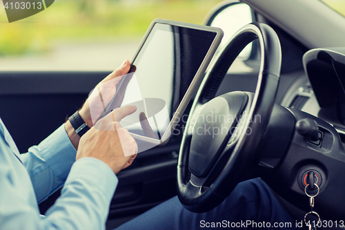 Image of close up of young man with tablet pc driving car