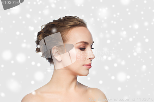 Image of beautiful young woman face over snow