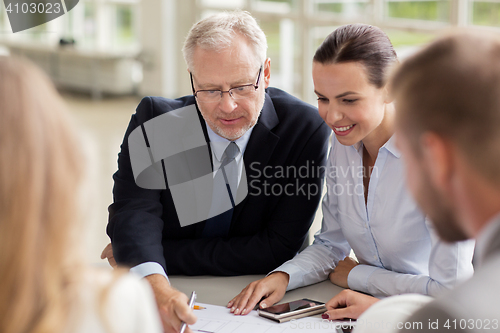 Image of architects with smartphone and blueprint at office