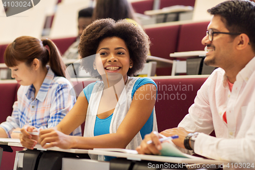 Image of group of students with notebooks in lecture hall