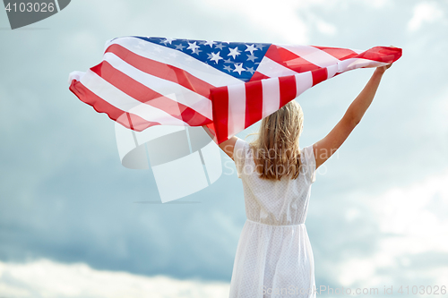 Image of happy young woman with american flag outdoors