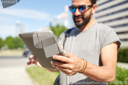 Image of close up of man with tablet pc in city