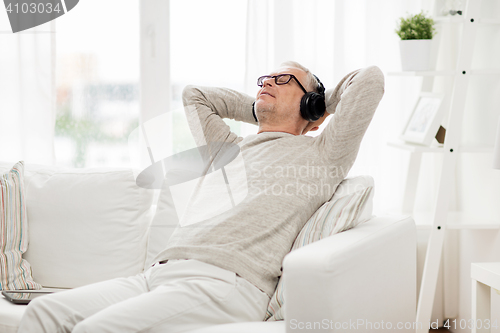 Image of happy man in headphones listening to music at home