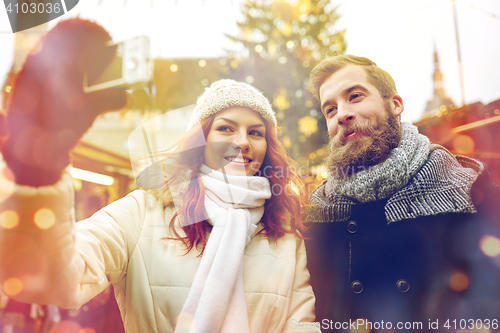 Image of couple taking selfie with smartphone in old town