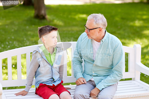 Image of grandfather and grandson talking at summer park