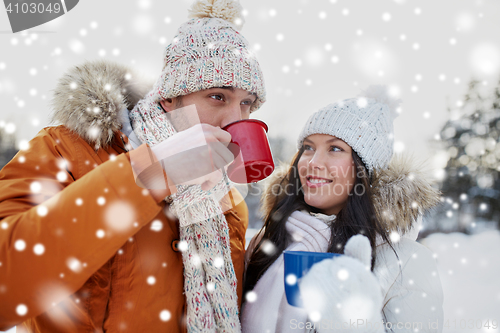 Image of happy couple with tea cups over winter landscape