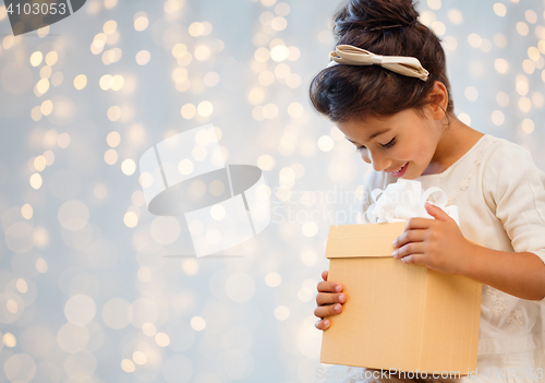 Image of smiling little girl with gift box over lights