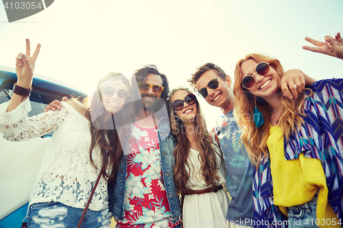 Image of hippie friends over minivan car showing peace sign