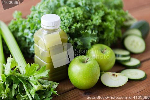 Image of close up of bottle with green juice and vegetables