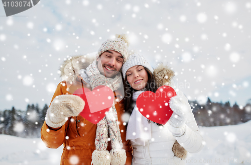 Image of happy couple with red hearts over winter landscape