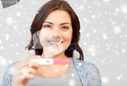 Image of happy smiling woman holding home pregnancy test