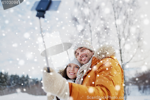 Image of happy couple taking selfie by smartphone in winter