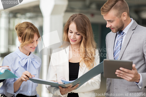 Image of business team with tablet pc and folders at office