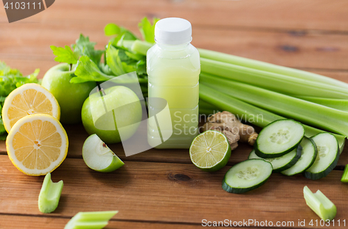 Image of close up of bottle with green juice and vegetables