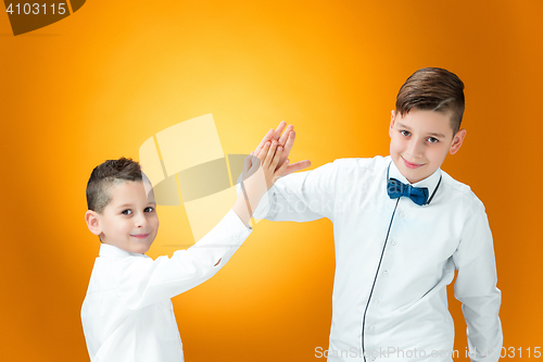 Image of Happy children congratulating by palms with the victory