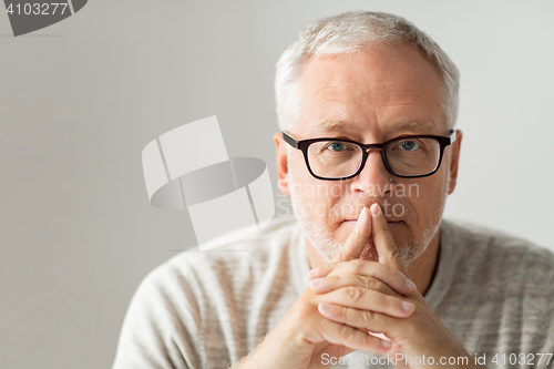 Image of close up of senior man in glasses thinking