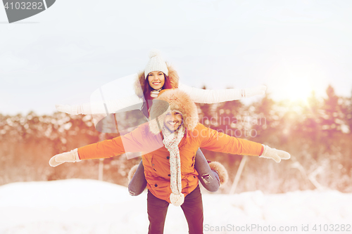 Image of happy couple having fun over winter background