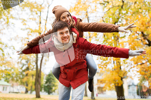 Image of happy young couple having fun in autumn park