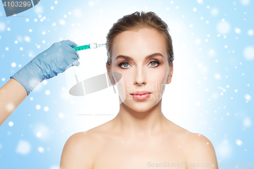 Image of woman face and hand with syringe making injection