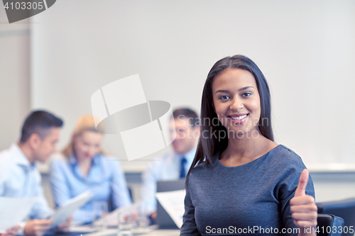 Image of group of smiling businesspeople meeting in office