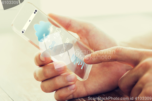 Image of close up of male hand with weather cast smartphone