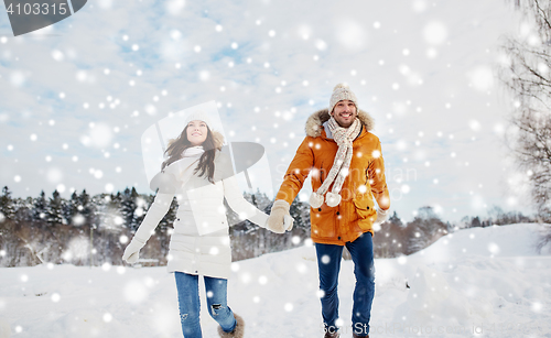 Image of happy couple running in winter snow