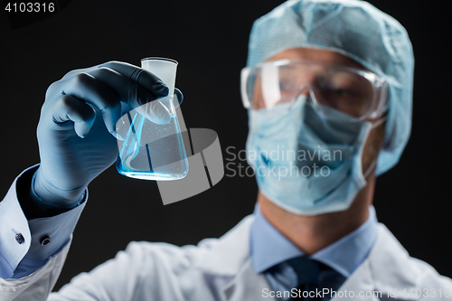 Image of close up of scientist holding flask with chemical