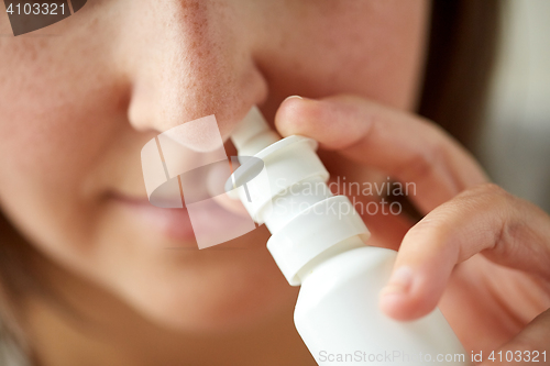 Image of close up of sick woman using nasal spray