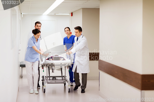 Image of medics with woman on hospital gurney at emergency