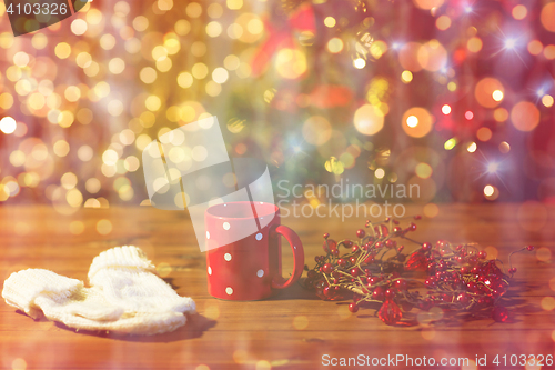Image of tea cup with mittens and christmas decoration