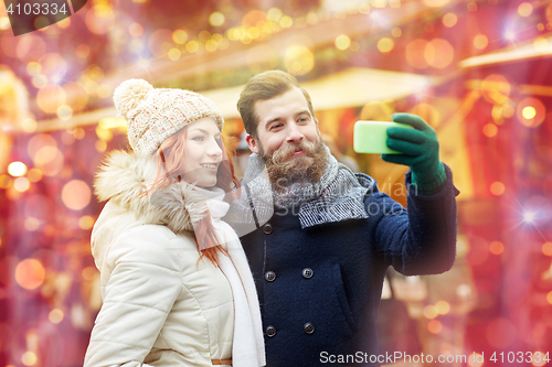 Image of couple taking selfie with smartphone in old town