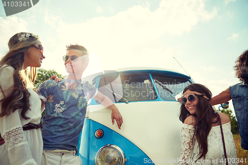 Image of smiling young hippie friends over minivan car