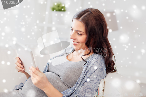 Image of happy pregnant woman with tablet pc at home