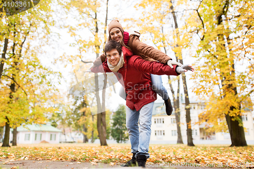 Image of happy young couple having fun in autumn park