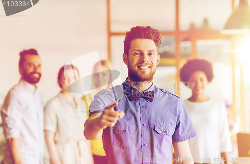 Image of happy man pointing finger at you over office team