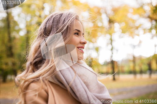 Image of beautiful happy young woman smiling in autumn park
