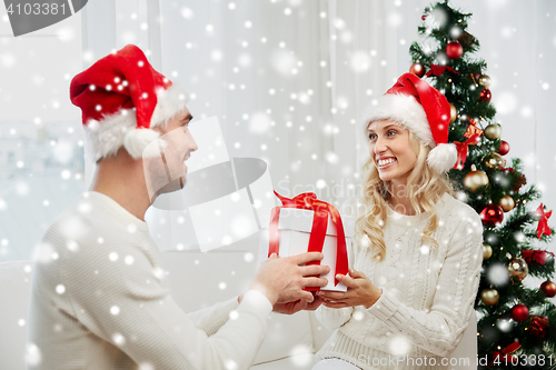 Image of happy couple at home with christmas gift box