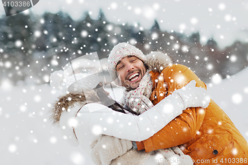 Image of happy couple hugging and laughing in winter