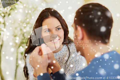 Image of happy couple holding hands at restaurant or cafe