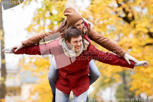 Image of happy young couple having fun in autumn park