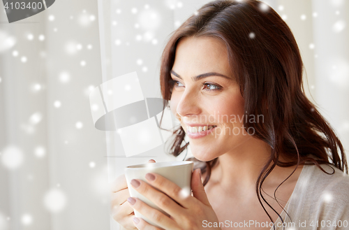 Image of happy woman with cup of tea or coffee at home